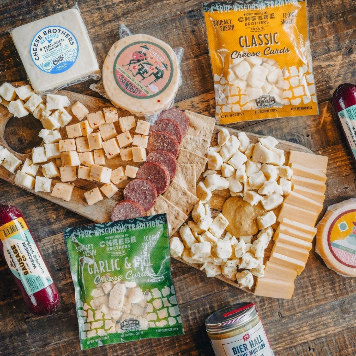 Assorted cheese, crackers, and charcuterie on a wooden board with visible branding.