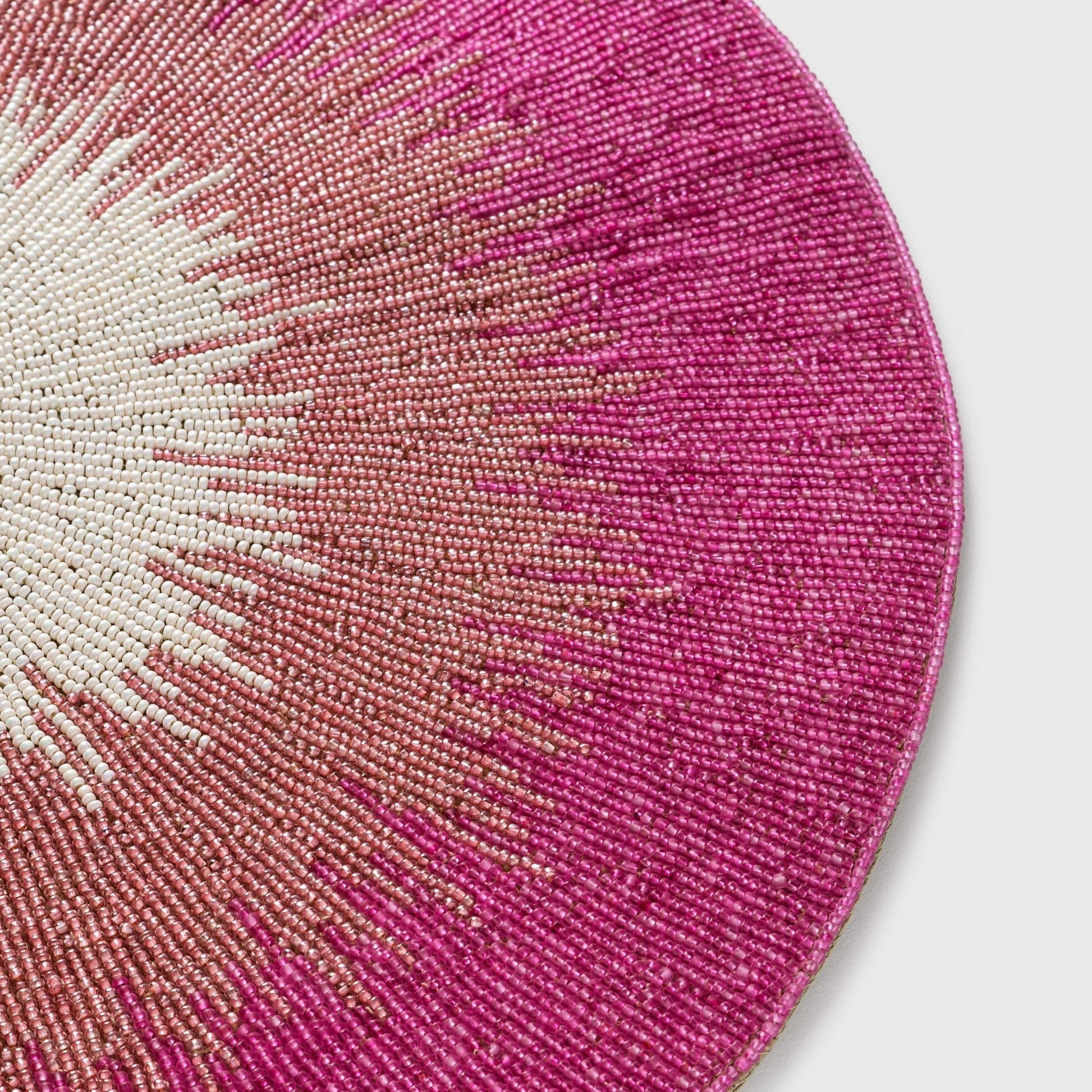 Close-up of hand beading on pink placemat