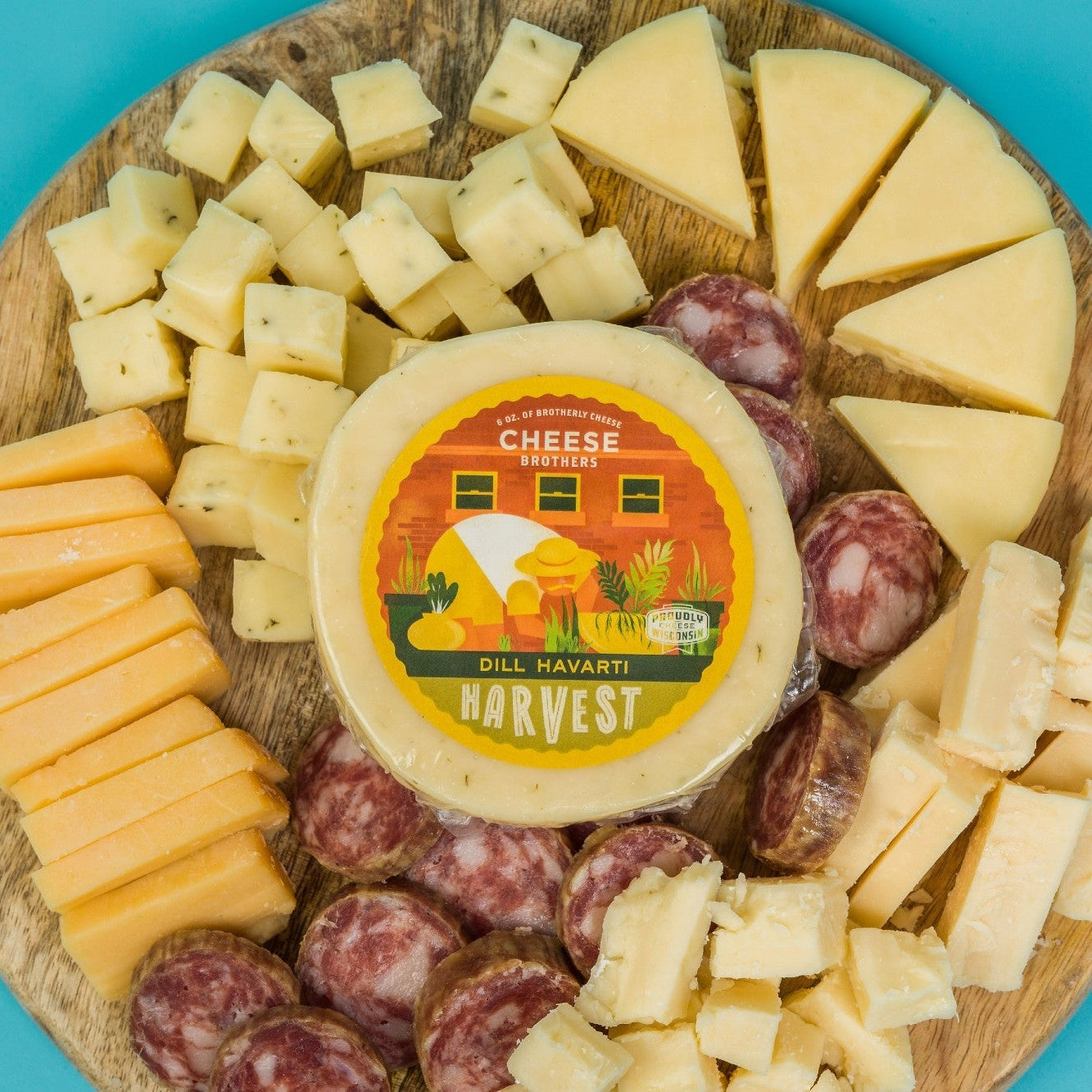 Assorted cheeses and sausages on a wooden board with a 'Harvest' label on a blue background