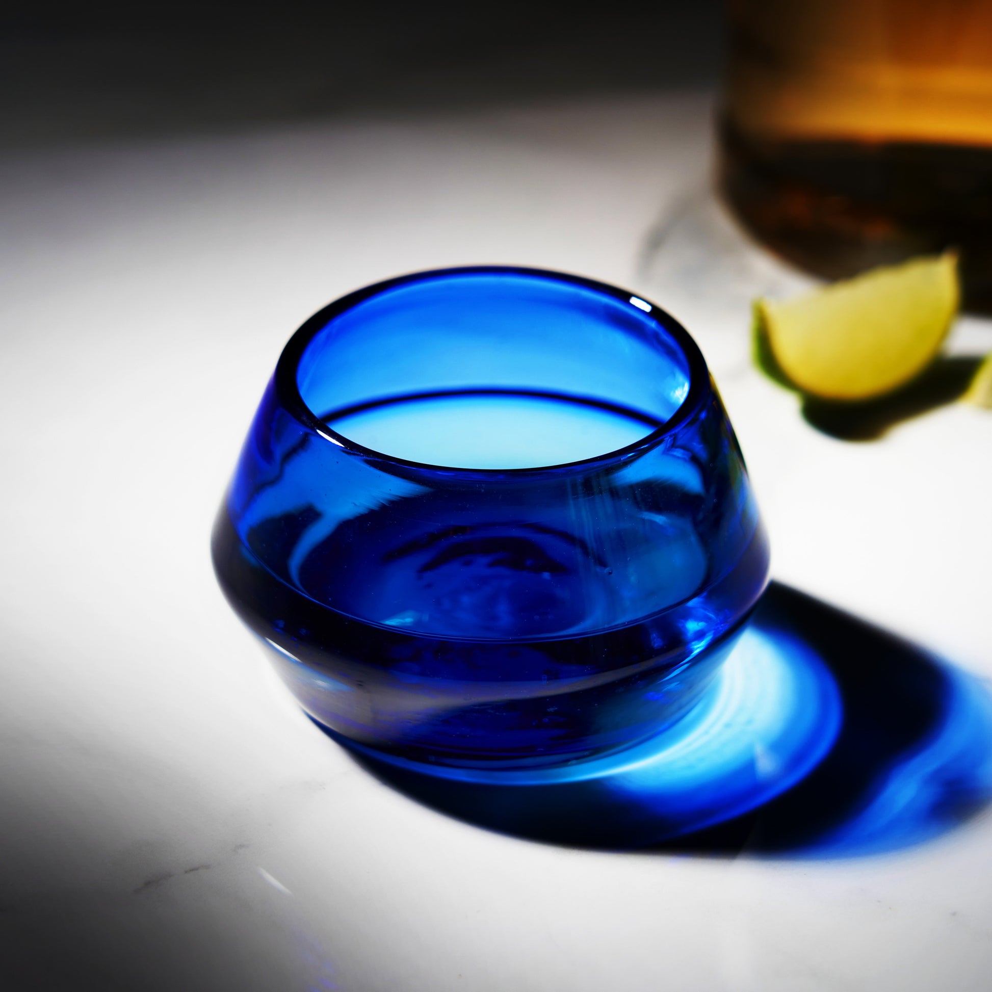 Cobalt copita glass with tequila being poured